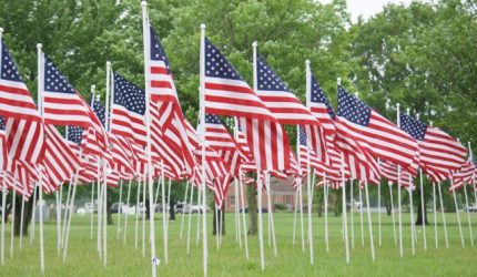 multiple US flags in ground at memorial
